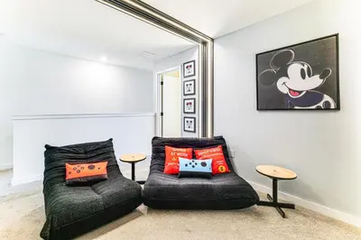 a room with a couch and a chair with pillows at 4 Mi to Disney! Pet-Friendly Home with Pool Access in Kissimmee