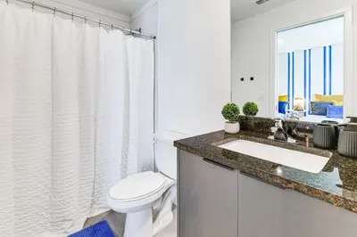 a white bathroom with a toilet and a sink at 4 Mi to Disney! Pet-Friendly Home with Pool Access in Kissimmee