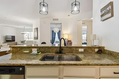 a kitchen with a sink and a living room at Apartamento Vista Cay: ao lado do UNIVERSAL in Orlando