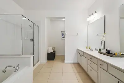 a white bathroom with two sinks and a shower at Apartamento Vista Cay: ao lado do UNIVERSAL in Orlando