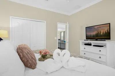 a white room with a bed and a tv at Fun Family Villa Pool BBQ Near Disney World in Kissimmee