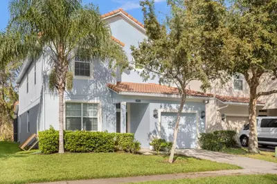 a white house with trees in front of it at Fun Family Villa Pool BBQ Near Disney World in Kissimmee