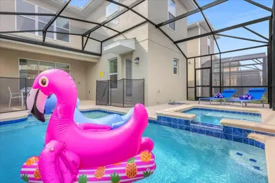a pink inflatable pink swan in a swimming pool at Disney Escape Villa Pool Resort Amenities in Kissimmee