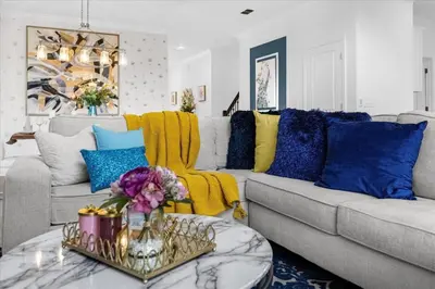 a living room with a couch with blue and yellow pillows at Disney Escape Villa Pool Resort Amenities in Kissimmee