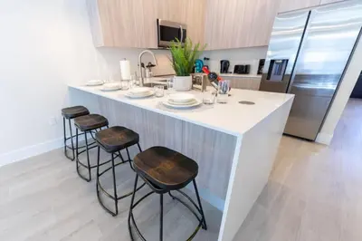 a kitchen with a large white island with stools at Disney Escape 3BR Home Pool in Orlando