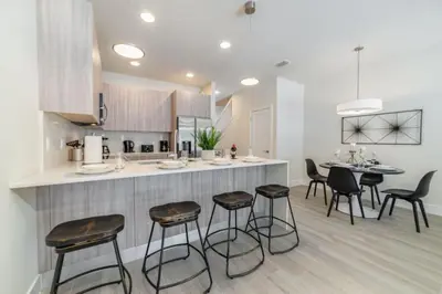 a kitchen with a counter and stools in a room at Disney Escape 3BR Home Pool in Orlando