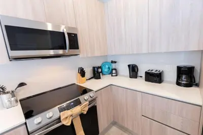 a small kitchen with a microwave and a stove at Disney Escape 3BR Home Pool in Orlando