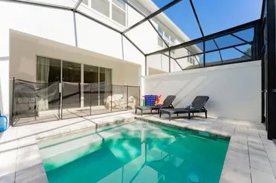 a swimming pool with two chairs and a house at Disney Escape 3BR Home Pool in Orlando