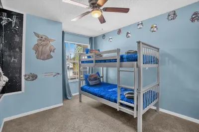 a bedroom with two bunk beds and a ceiling fan at Disney Pool Retreat Modern Home Sleeps 8 in Kissimmee
