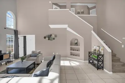 a living room with a couch and a table at Disney Pool Retreat Modern Home Sleeps 8 in Kissimmee
