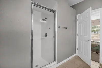 a shower with a glass door in a bathroom at Disney Pool Retreat Modern Home Sleeps 8 in Kissimmee
