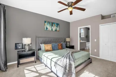 a bedroom with a bed and a ceiling fan at Disney Pool Retreat Modern Home Sleeps 8 in Kissimmee