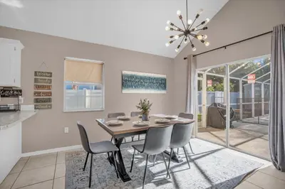 a dining room with a table and chairs at Disney Pool Retreat Modern Home Sleeps 8 in Kissimmee