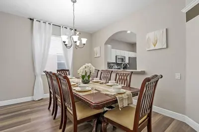 a kitchen and dining room with a table and chairs at Cozy Pool Villa Minutes Drive to Disney in Orlando