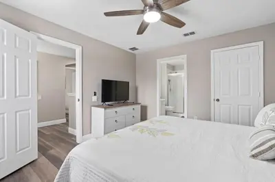 a bedroom with a white bed and a ceiling fan at Cozy Pool Villa Minutes Drive to Disney in Orlando