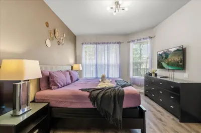 a bedroom with a purple bed with a stuffed animal on it at Large Family Retreat Pool BBQ Disney Parks Nearby in Orlando