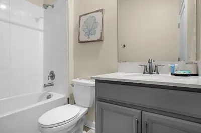 a white bathroom with a toilet and a sink at Stylish Resort Home Game Room Poo Near Disney in Kissimmee