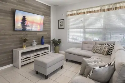 a living room with a couch and a tv at Bright Resort Home Pool Near Disney in Orlando