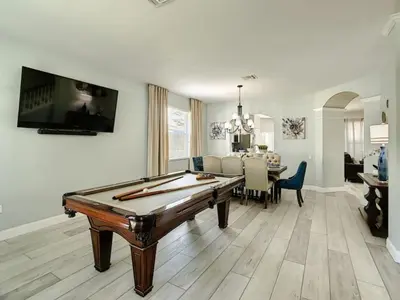 a living room with a pool table and a dining room at Modern 6BR Resort Private Pool Near Disney in Orlando