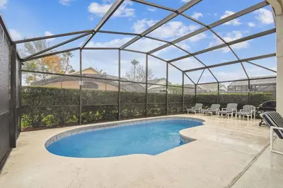 a swimming pool in a tent with chairs around it at Casa c/ Piscina Privativa e Game Room in Kissimmee