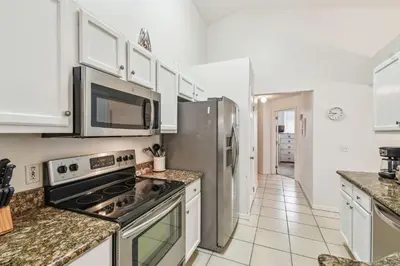 a kitchen with stainless steel appliances and white cabinets at Casa c/ Piscina Privativa e Game Room in Kissimmee