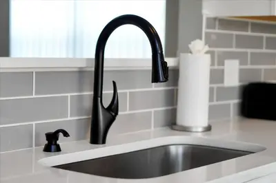 a kitchen sink with a black faucet at Family-Friendly 6-Bedroom Villa with Pool Game Room and Themed Bedrooms at Emerald Island Resort in Kissimmee