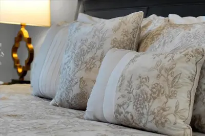 a group of pillows on a bed with a lamp at Family-Friendly 6-Bedroom Villa with Pool Game Room and Themed Bedrooms at Emerald Island Resort in Kissimmee