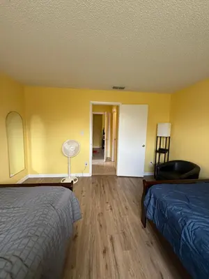 a hotel room with two beds and a hallway at Sunny Orlando Oasis - Cozy 2 Bedroom house near Disney in Kissimmee