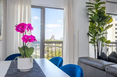 a dining room with a table with pink flowers on it at Modern 2BR Near Universal in Orlando