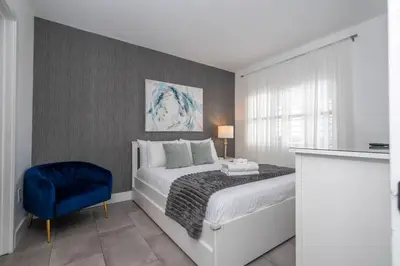 a bedroom with a bed and a blue chair at Modern 2BR Near Universal in Orlando