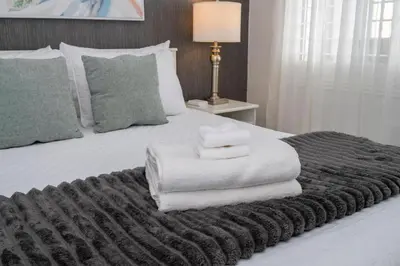 a bed with a pile of towels on it at Modern 2BR Near Universal in Orlando