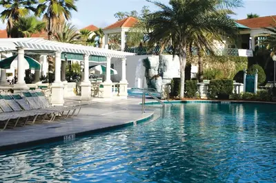 a pool at a resort with chairs and palm trees at Wyndham Star Island Resort-2BR- Apartment with Resort Access in Kissimmee
