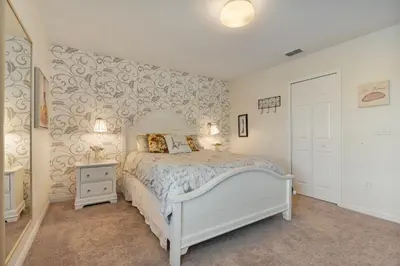 a bedroom with a bed and a wall with wallpaper at 4BR Lake View Home Bella Vida in Kissimmee