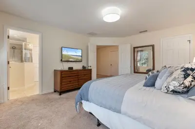 a bedroom with a bed and a dresser and a television at 4BR Lake View Home Bella Vida in Kissimmee