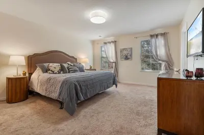 a bedroom with a bed and two windows at 4BR Lake View Home Bella Vida in Kissimmee