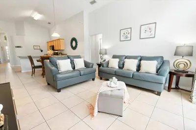 a living room with two blue couches and a table at Elegant Emerald Island – Near Disney in Kissimmee
