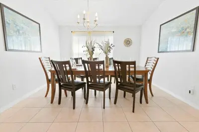 a dining room with a wooden table and chairs at Elegant Emerald Island – Near Disney in Kissimmee