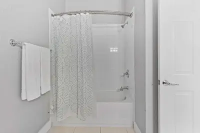 a bathroom with a shower with a white shower curtain at Amplo Apartamento 3 Quartos no Vista Cay Resort in Orlando