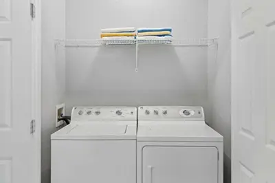 a white kitchen with a stove and towels on a shelf at Amplo Apartamento 3 Quartos no Vista Cay Resort in Orlando