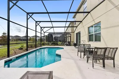 a swimming pool in a house with a table and chairs at Home 08 Bedrooms At Bella Vida in Kissimmee