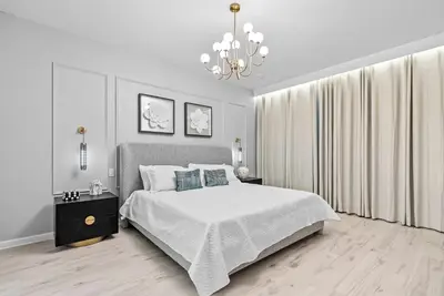 a white bedroom with a large bed and a chandelier at Home 08 Bedrooms At Bella Vida in Kissimmee