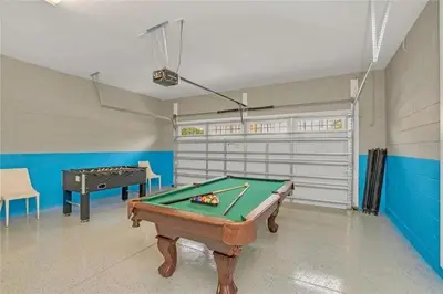a room with a pool table and a garage at Vila 8Q Disney c/ Piscina, Spa e Bar Temático in Orlando