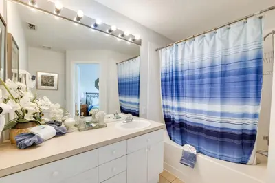 a bathroom with a sink and a blue shower curtain at Family-Friendly Resort Getaway 5 Mi to Disney! in Kissimmee