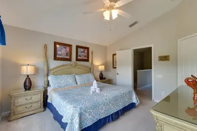 a bedroom with a bed with a blue comforter at Pool and Resort Perks Family Retreat Near Disney! in Kissimmee