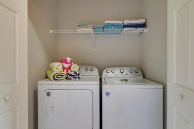 two washing machines in a laundry room with towels at Pool and Resort Perks Family Retreat Near Disney! in Kissimmee
