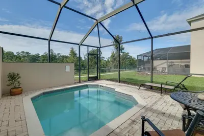 an indoor swimming pool in a house with a patio at Pool and Resort Perks Family Retreat Near Disney! in Kissimmee