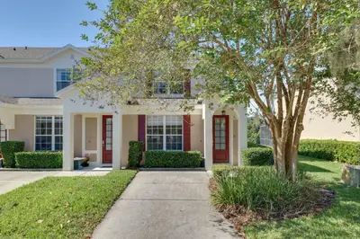 a house with a tree and a sidewalk at Pool and Resort Perks Family Retreat Near Disney! in Kissimmee