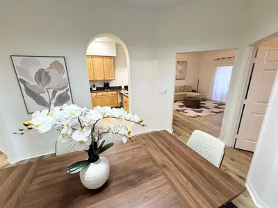 a vase of flowers on a table in a living room at 2BR Condo Close to Disney - Gated, Pool & Hot Tub in Kissimmee
