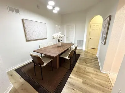 a dining room with a wooden table and chairs at 2BR Condo Close to Disney - Gated, Pool & Hot Tub in Kissimmee