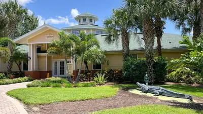 a house with a large alligator in front of it at 2BR Condo Close to Disney - Gated, Pool & Hot Tub in Kissimmee